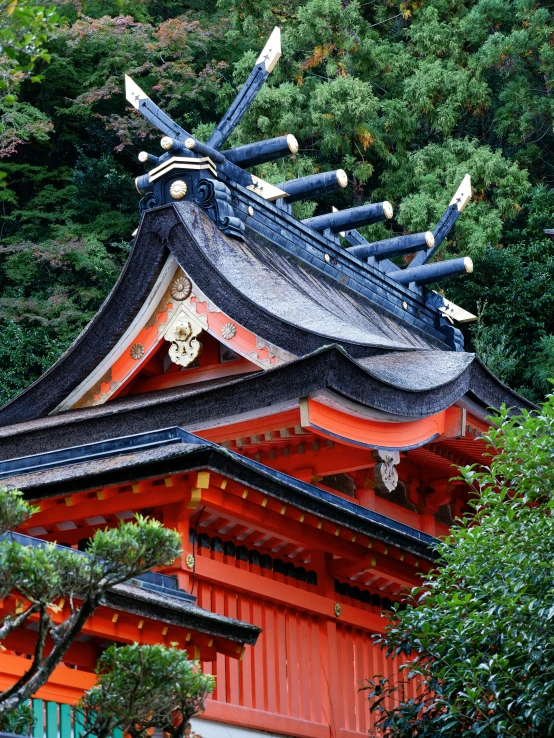 a red pagoda is in the middle of trees and bushes