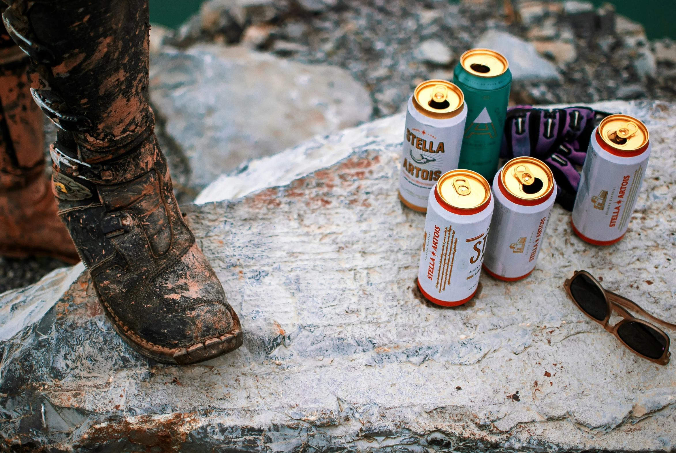 a bunch of different colored cans sitting on top of a stone