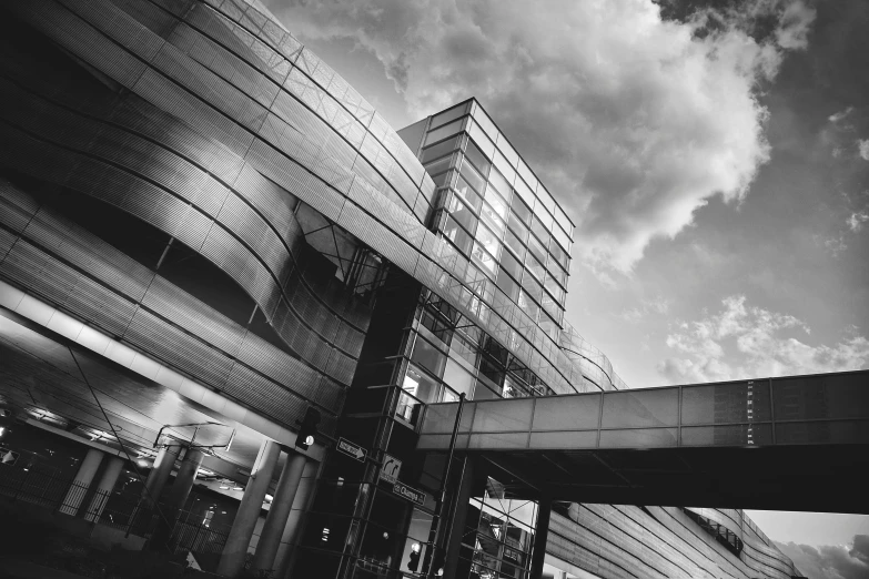 a building with many windows near by under a cloudy sky