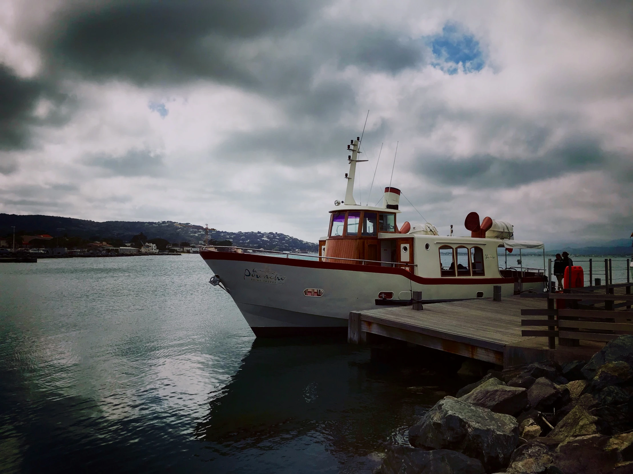 a tug boat docked next to a long dock