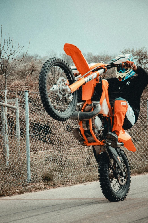 a person is performing a wheelie trick on their dirt bike