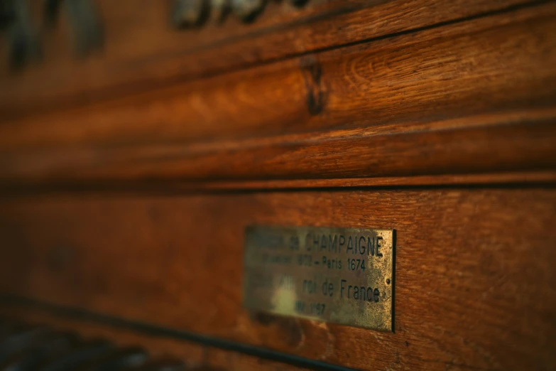 this is an old, worn - out brown piano with a plaque on it