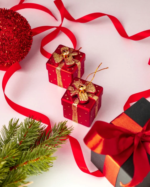 three presents wrapped in red ribbon and decorations