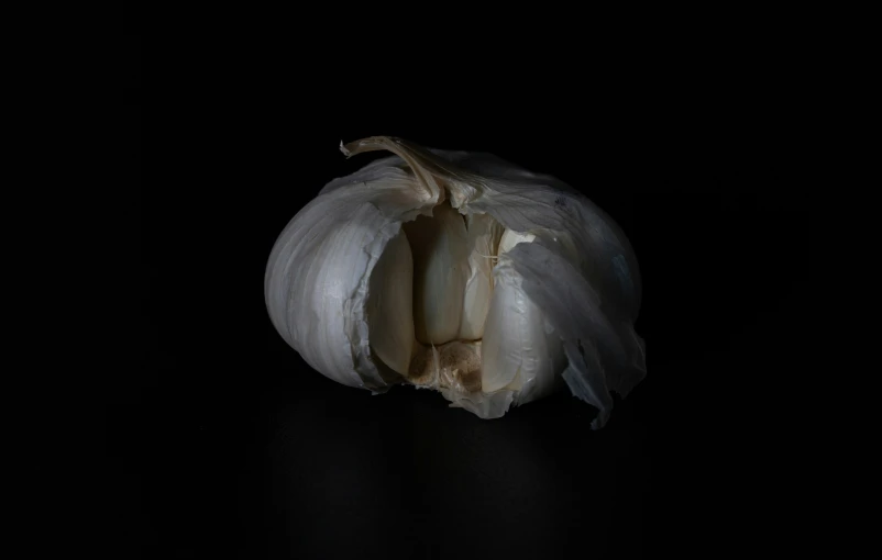 an onion on a black surface, with a slice missing