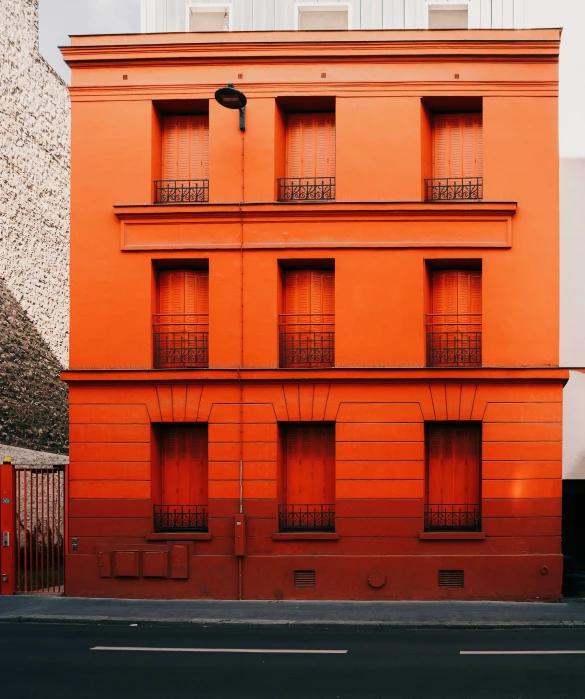 an orange building sits in front of a gate