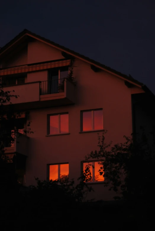 a red colored house with the moon visible