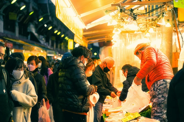 an outdoor market area with various stalls full of people and food