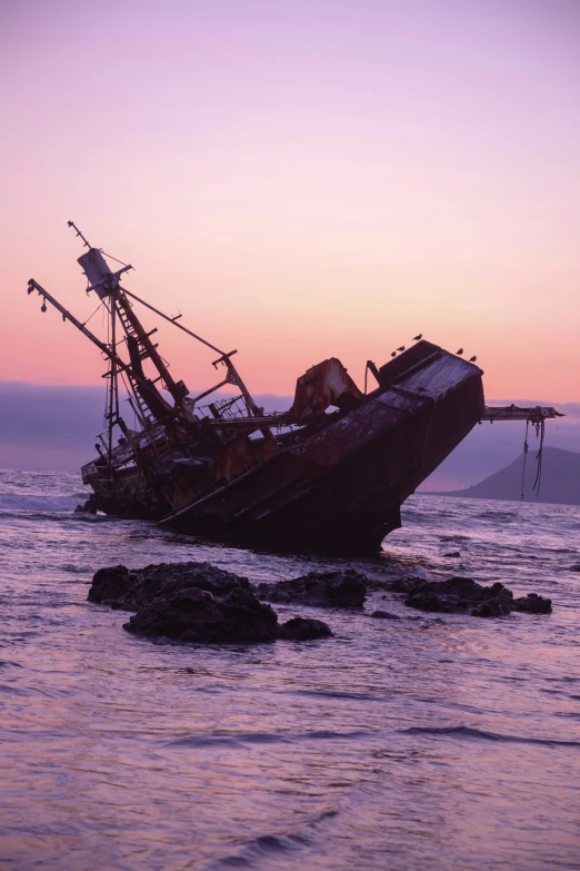 an old wooden boat with rusty masts is floating in the ocean