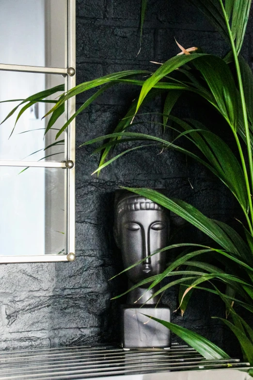 a statue sitting under some plants on top of a table