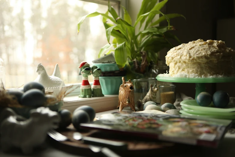 a cake sits on a table near some plants and eggs