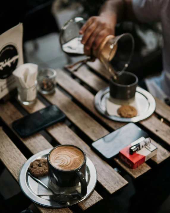 a person pouring coffee into a cup on a plate