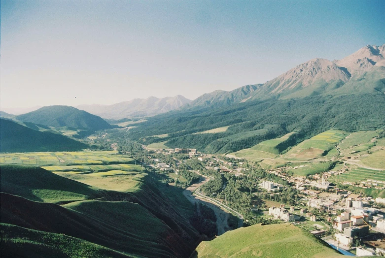 a scenic view of a green valley and small town