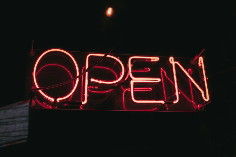 a neon open sign lit up in the dark