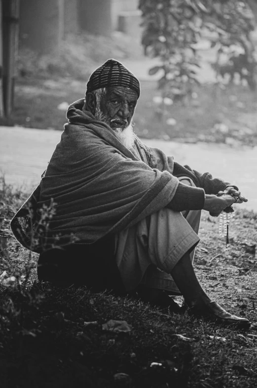 a man with a long white beard sitting on the ground