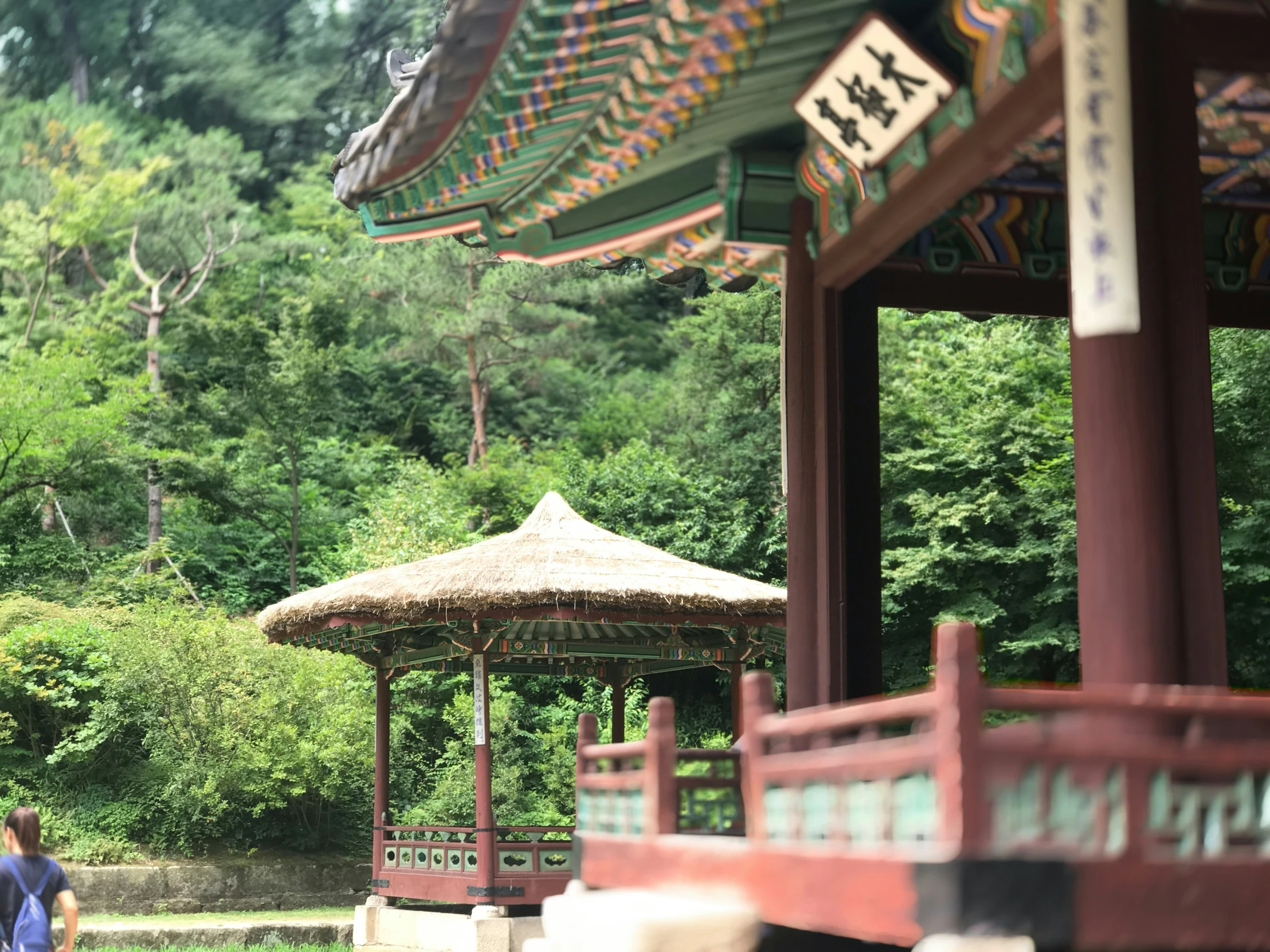 people are walking around a gazebo in the middle of a park