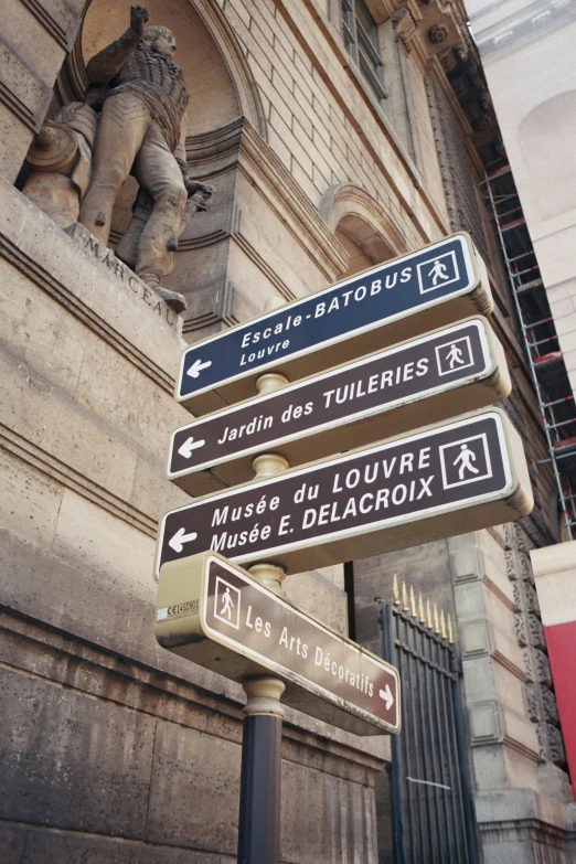 three directional signs pointing in two directions on a pole