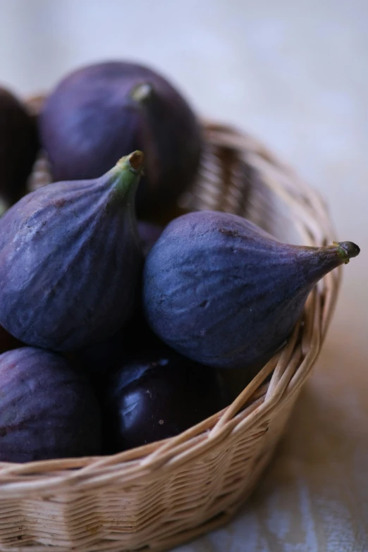 a basket filled with purple fruit sitting on top of a table