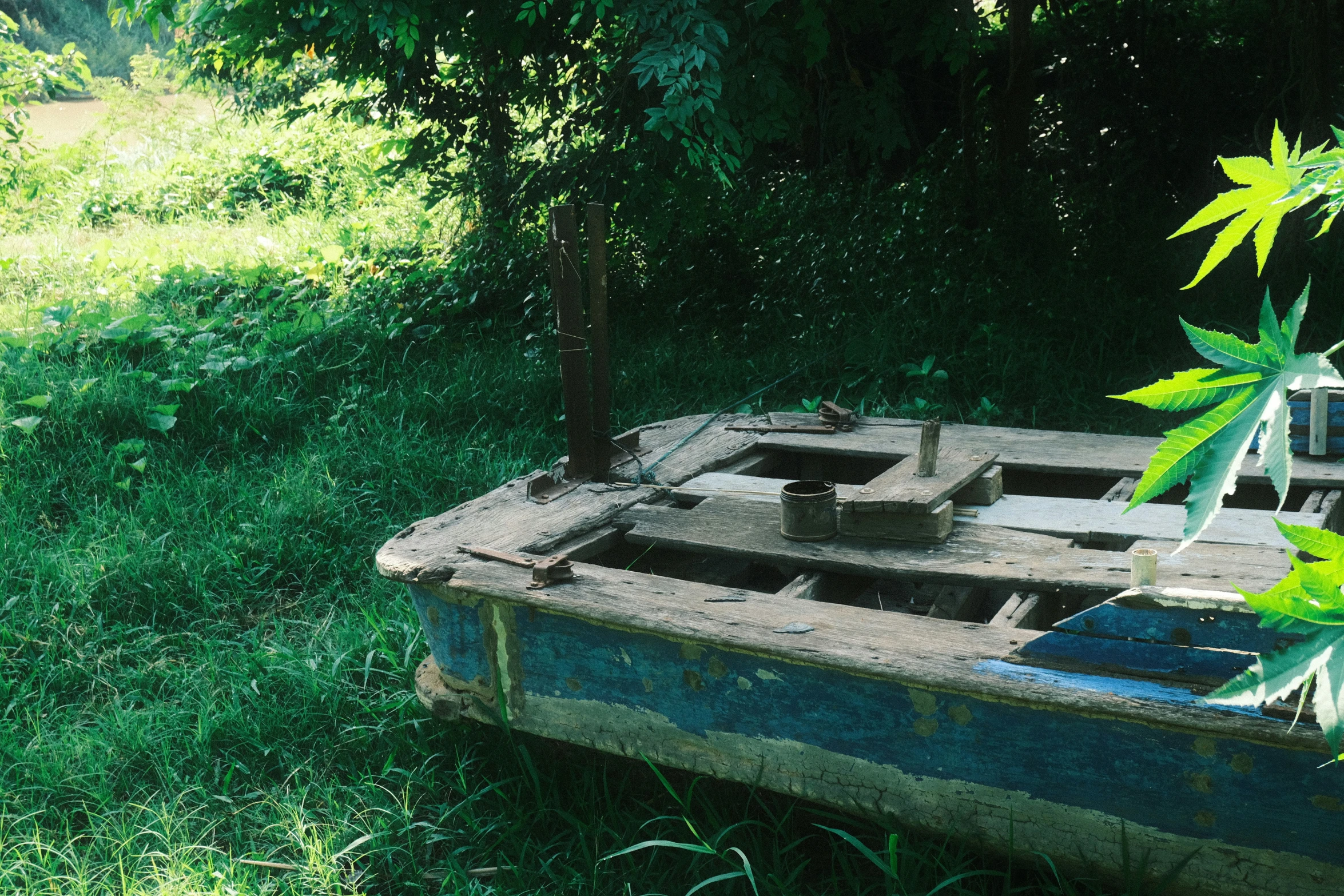 a dilapidated wooden boat out in the grass