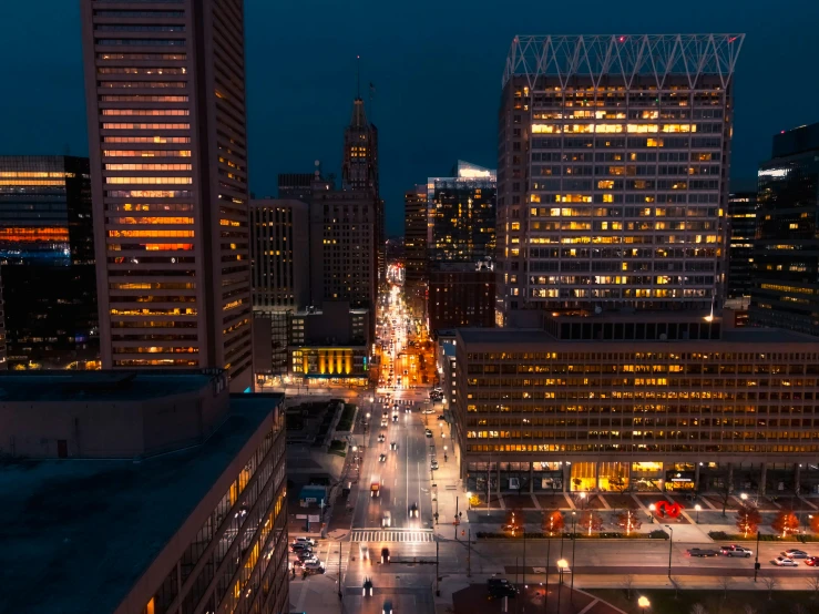 some buildings lights people and cars in the street