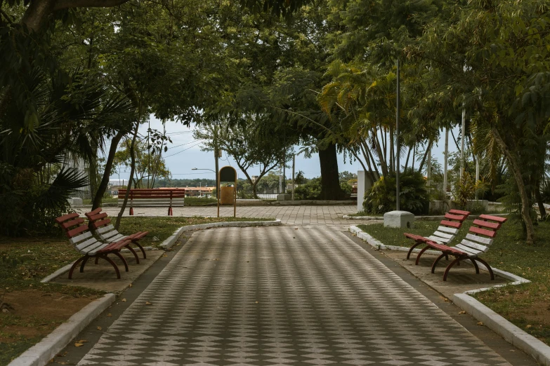 benches sitting on a walkway next to the water