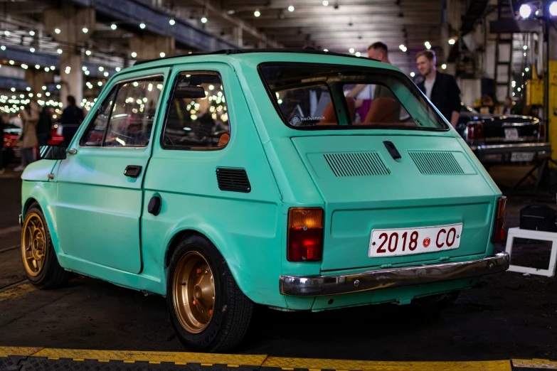 a mint green old car that has some light on