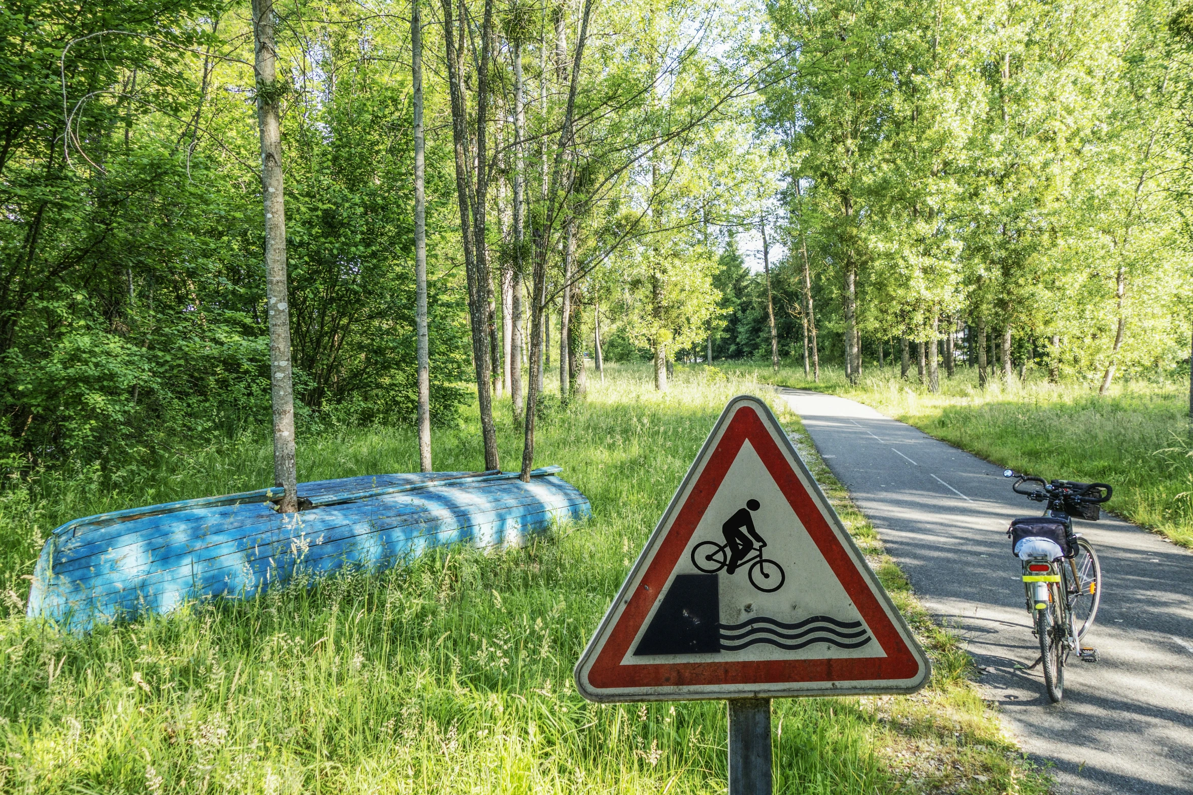 a street sign sitting in the grass near a road