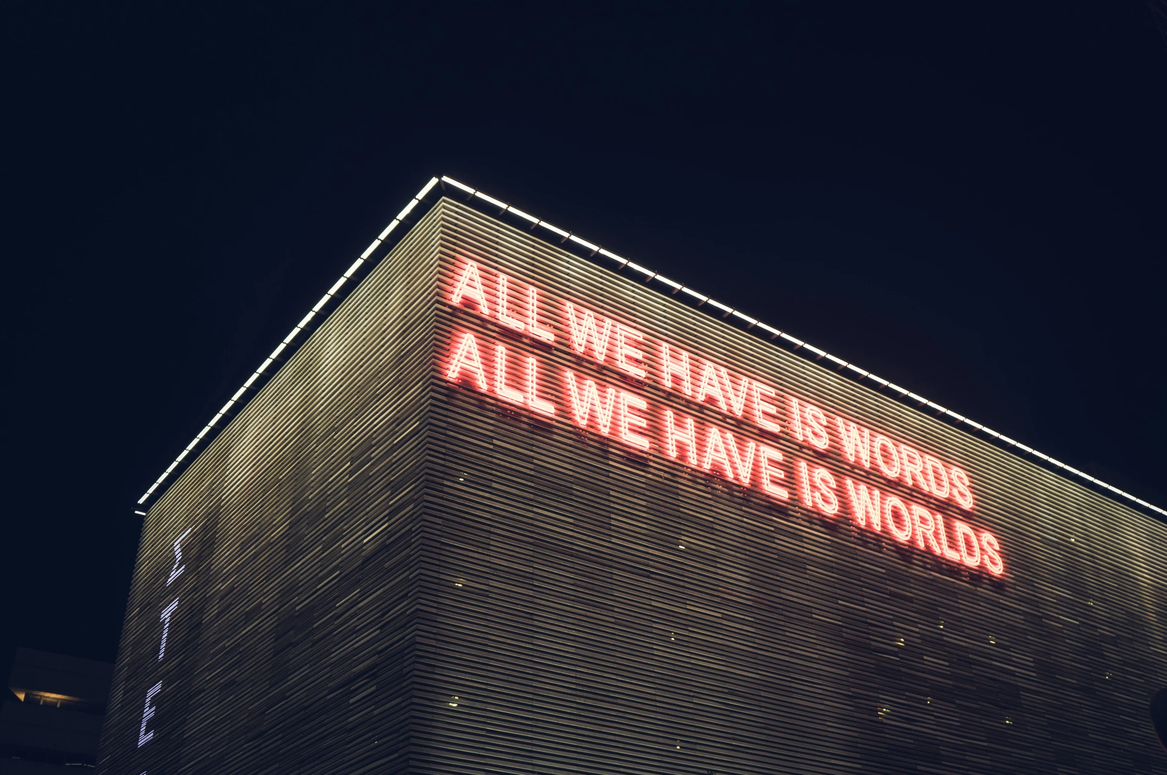 a sign is lit up on the side of the building