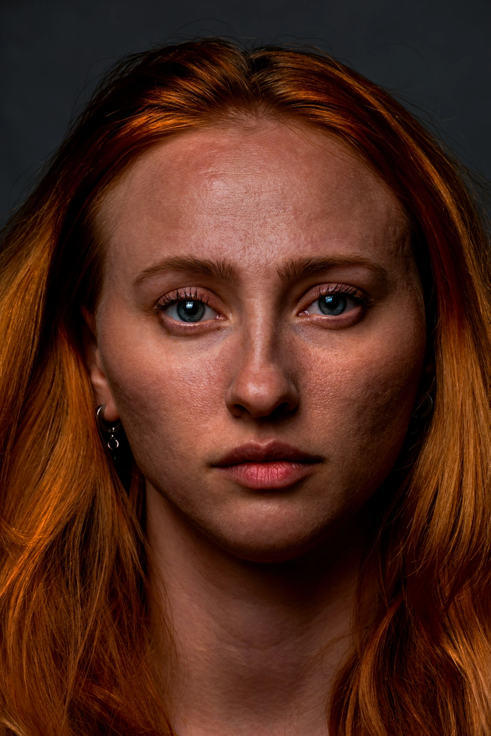 a woman with orange hair and piercings