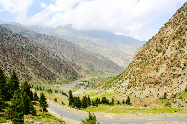 the road winding into a mountain valley is flanked by mountains