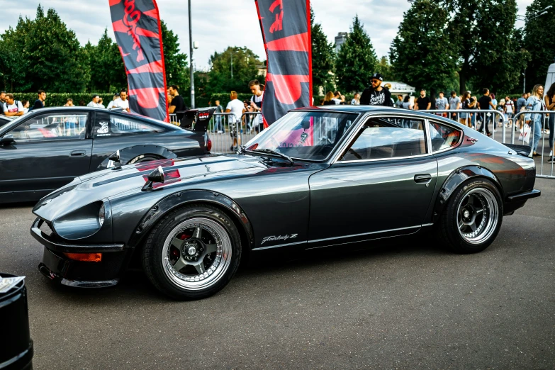 a car with its hood up and the number one on it parked in front of a crowd