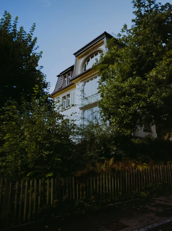 a large white building behind a wooden fence