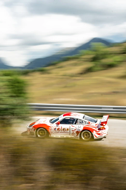 a porsche sports car racing down a rural track