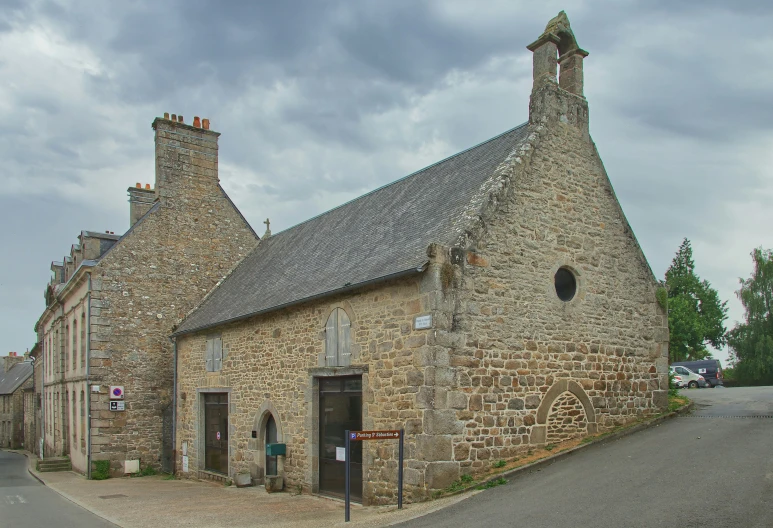 an old brick building sits alone on the side of a road