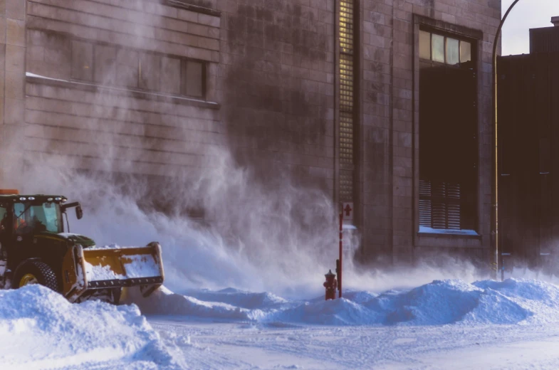 a tractor plowing snow down a city street