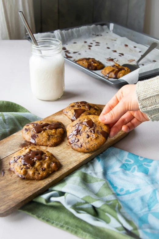 a person is grabbing a cookie onto a board