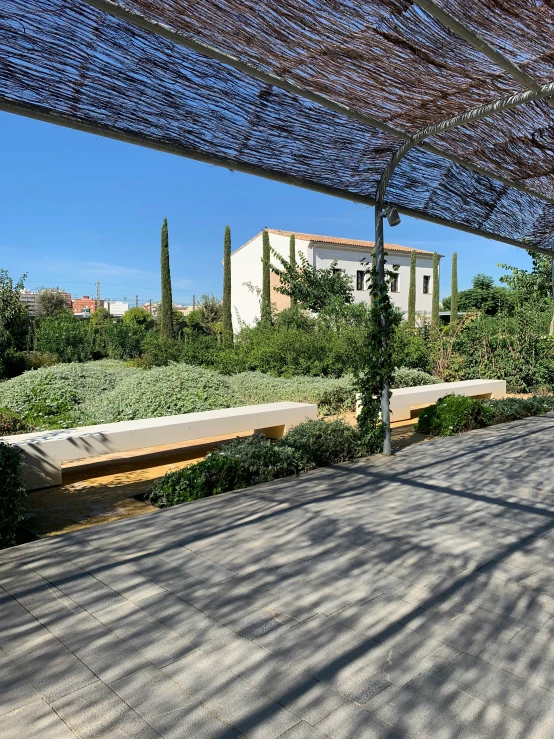 a patio that has a bench underneath a awning