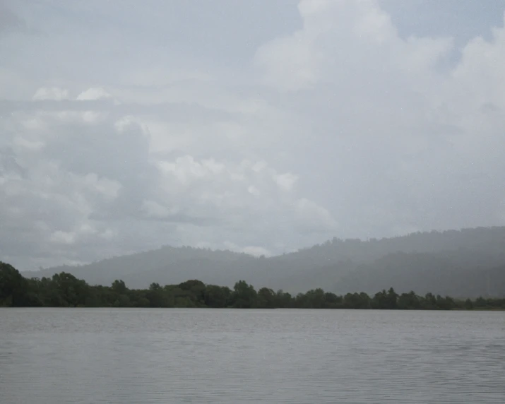 a lake with a very calm side, it is cloudy and green