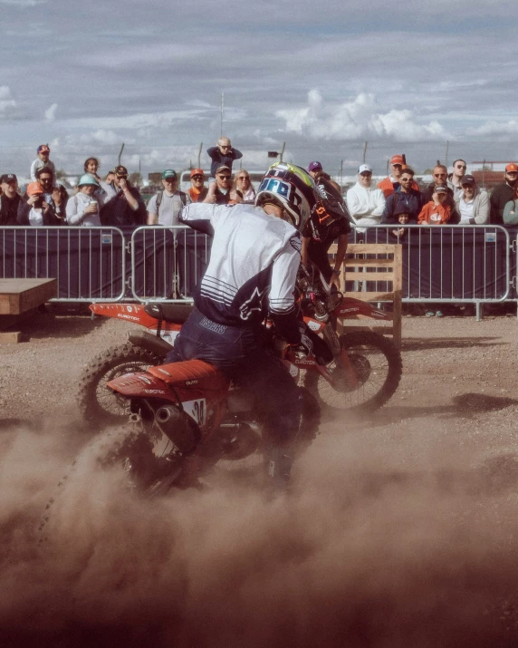 a guy riding his dirt bike is kicking up dust