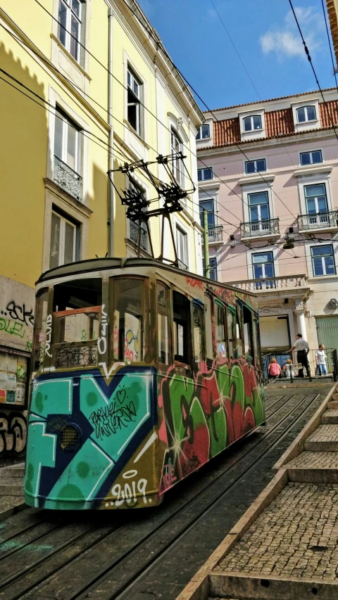 an electric train traveling along side buildings