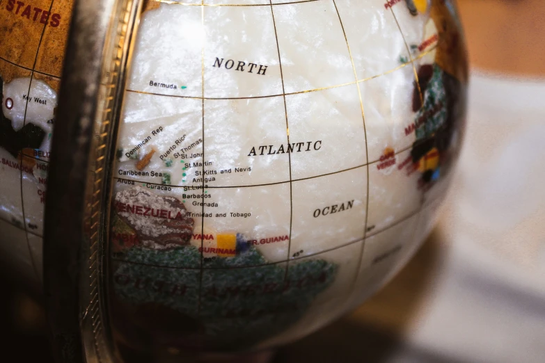 a glass globe with countries displayed with other world maps