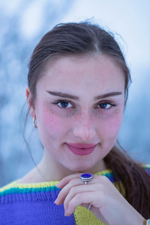 a  poses in the snow with her finger resting on her chin