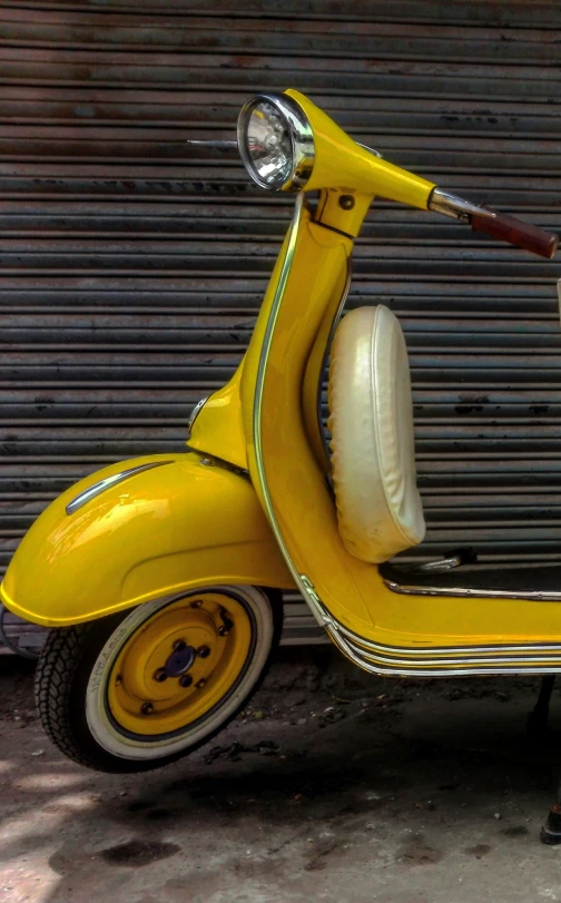 yellow scooter leaning against wall in warehouse setting