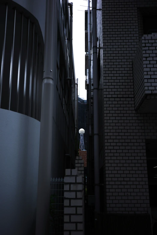 an alleyway with brick buildings near a street light