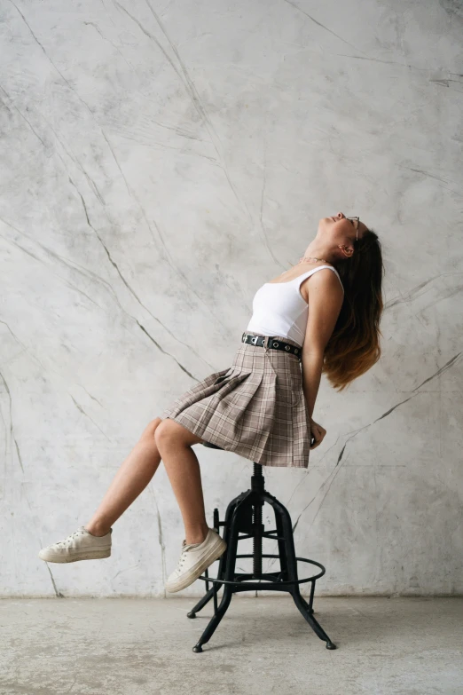 a woman who is in the air on top of a stool