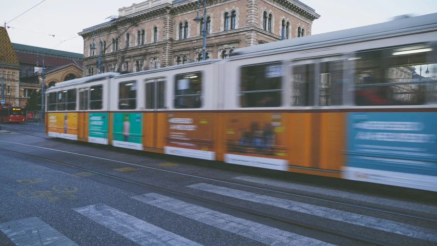 a trolley is moving along a city street