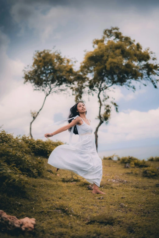 a woman in white is posing with her arms spread