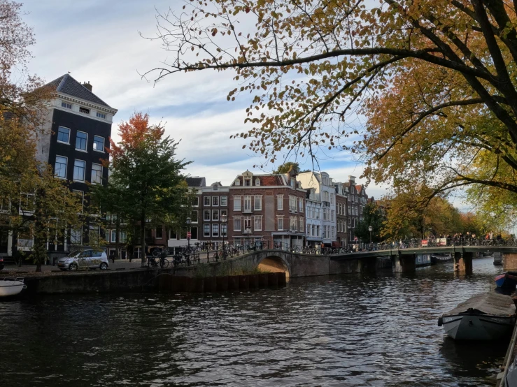 people are riding a boat down the canal in autumn