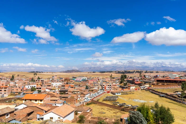 a city on top of a hilly landscape under a blue sky