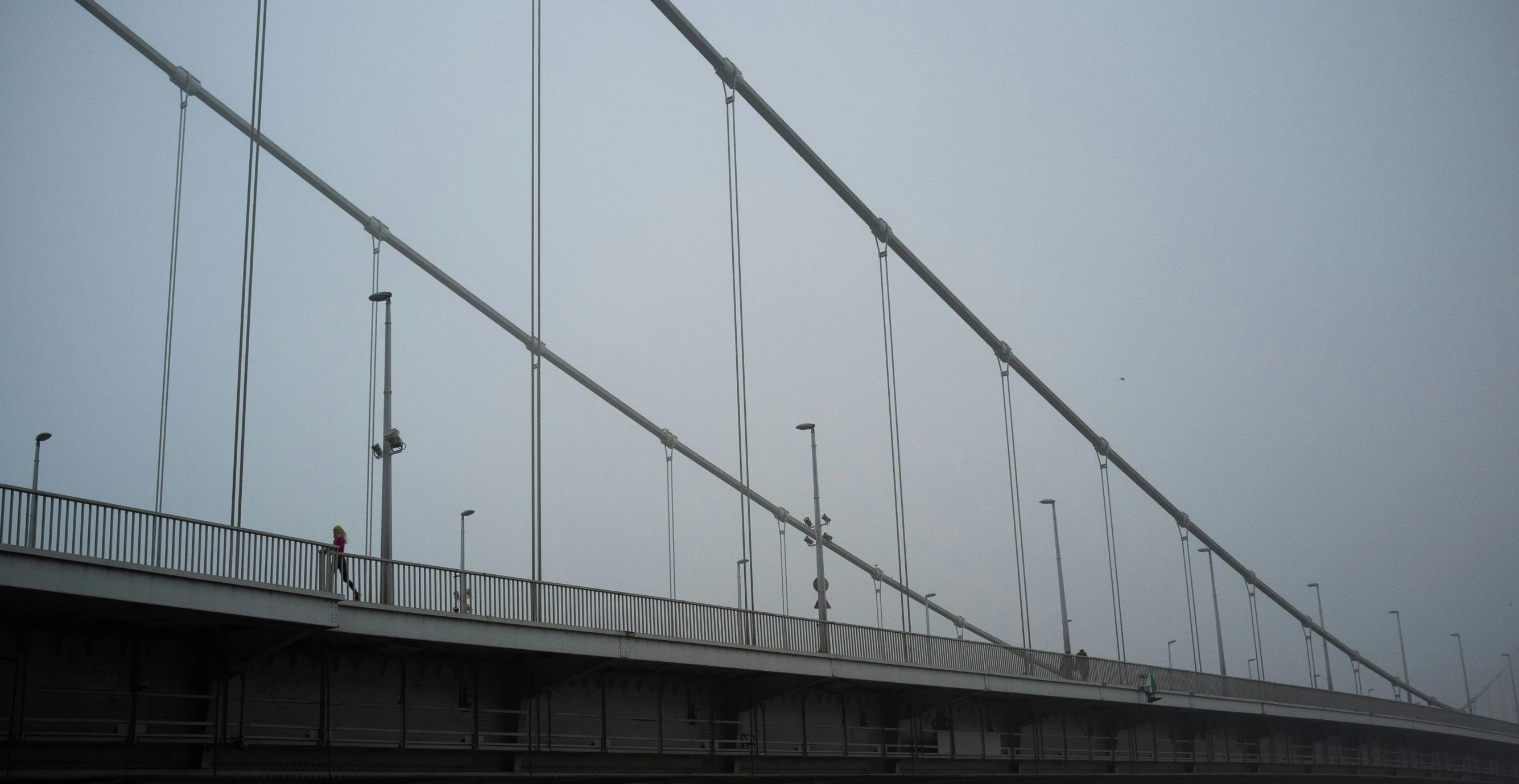 a bridge with traffic lights and people walking