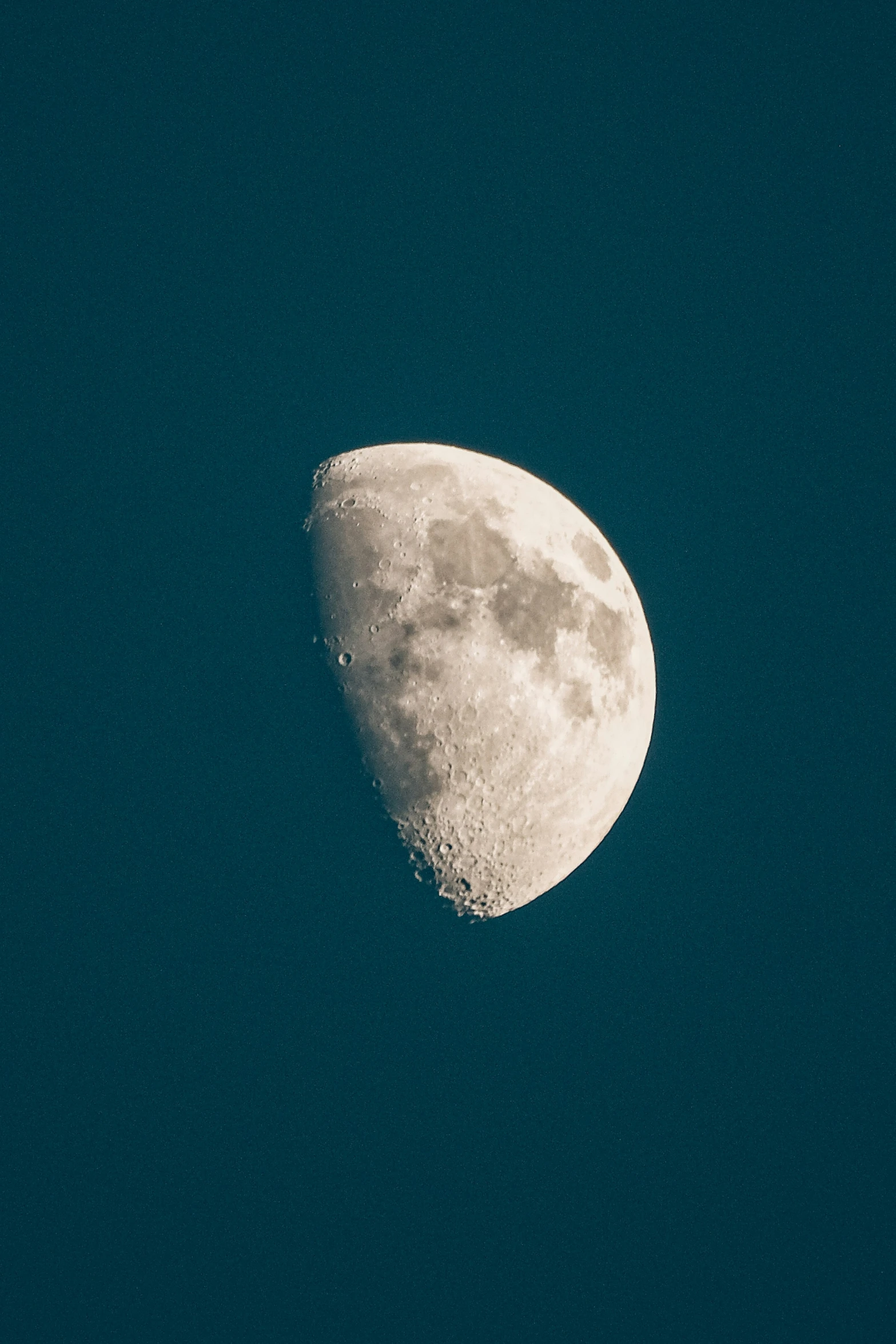 a half moon is shown against a blue sky